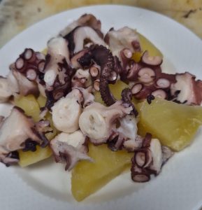 Exquisito pulpo a la gallega en plato blanco, reflejando la tradición culinaria de Saraiba.